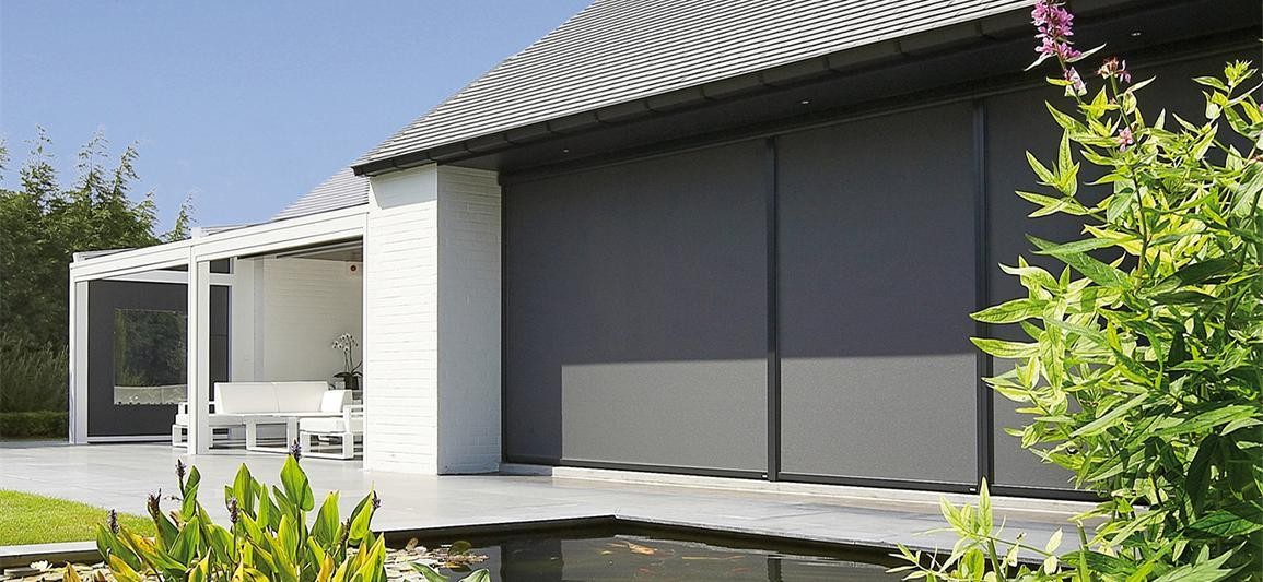 Motorized outdoor zip track blinds shading a modern villa terrace